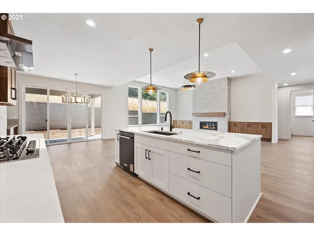 a kitchen with counter top space sink and living room view