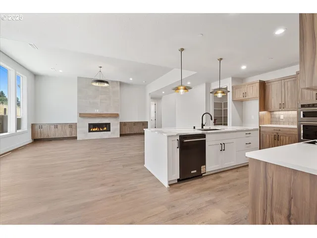 a large kitchen with cabinets wooden floor and stainless steel appliances