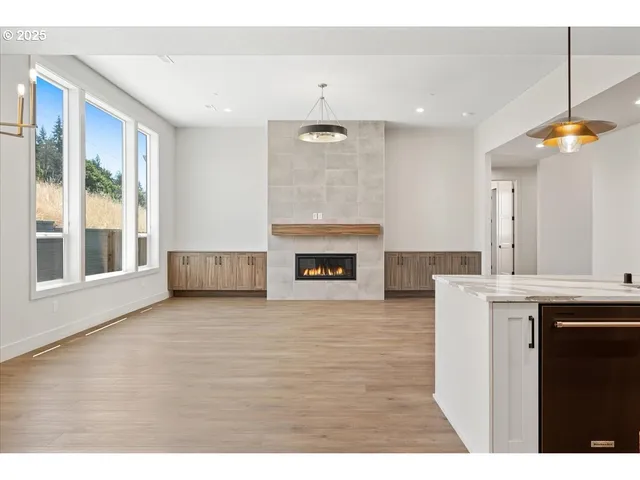 a view of an empty room with a fireplace and a window