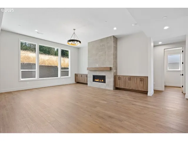 a view of a livingroom with wooden floor and a ceiling fan