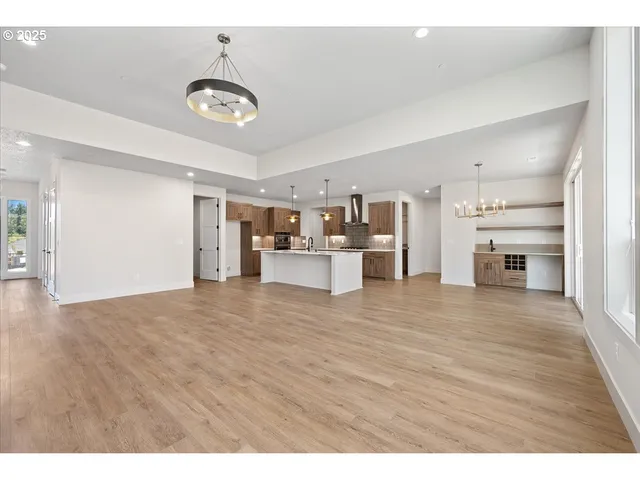 a view of a kitchen with a sink wooden cabinets and refrigerator