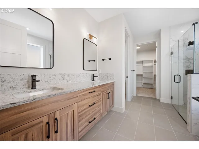 a spacious bathroom with a granite countertop sink mirror and shower
