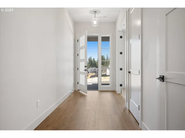a view of a hallway with wooden floor