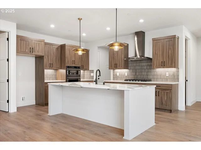 a kitchen with stainless steel appliances granite countertop a sink a refrigerator and a oven