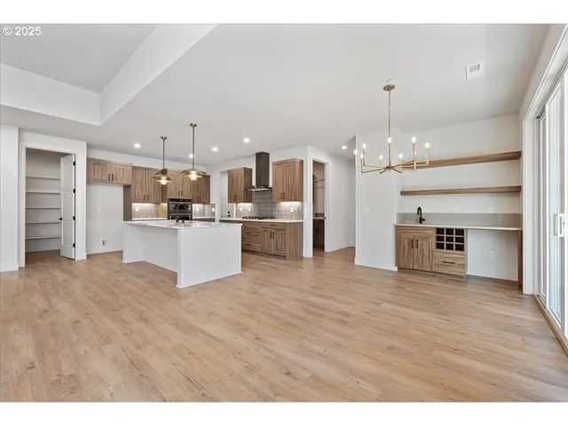 a view of a kitchen with a sink wooden cabinets and a fireplace