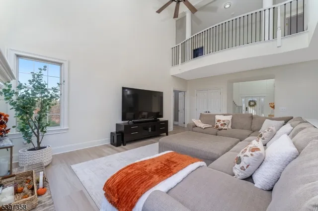 a kitchen with stainless steel appliances a microwave a stove a sink dishwasher a refrigerator and white cabinets with wooden floor