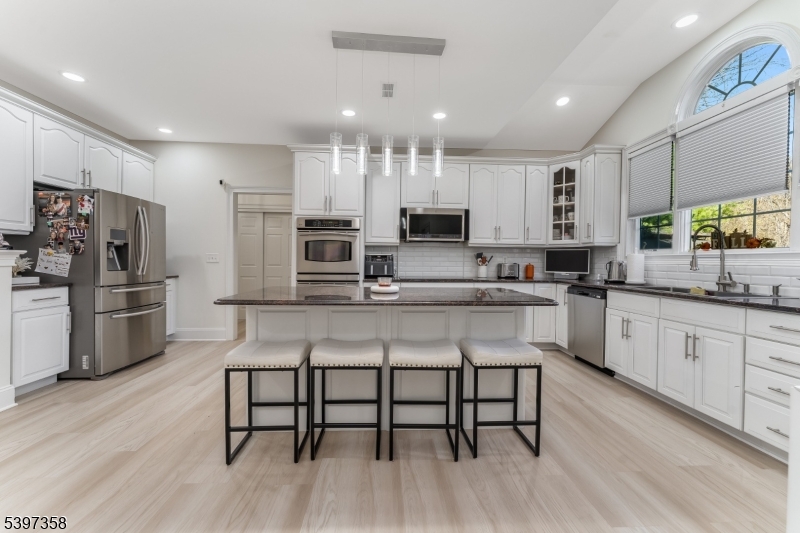 16 Perry Road Annandale, NJ 08801 - Photo 30 of 49 a kitchen with stainless steel appliances a microwave a stove a sink dishwasher a refrigerator and white cabinets with wooden floor
