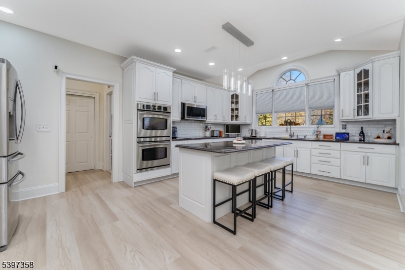 16 Perry Road Annandale, NJ 08801 - Photo 31 of 49 a kitchen with stainless steel appliances a microwave a stove a sink dishwasher a refrigerator and white cabinets with wooden floor