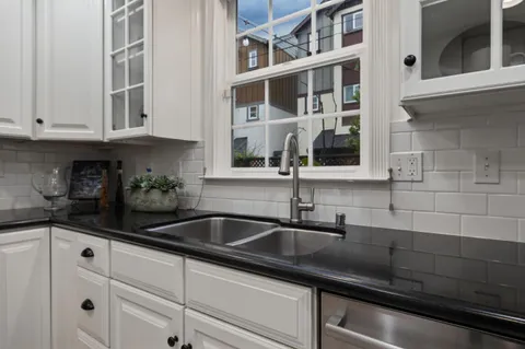 a kitchen with stainless steel appliances granite countertop white cabinets and a counter top space