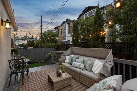a roof deck with couches and potted plants