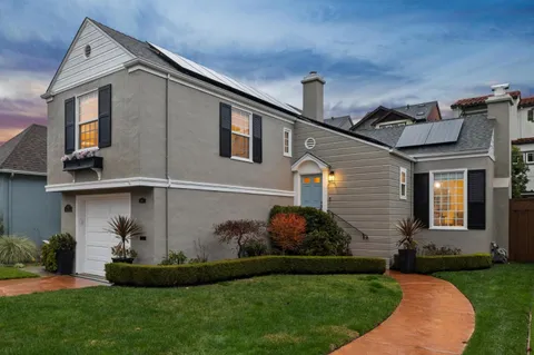 a front view of a house with a garden
