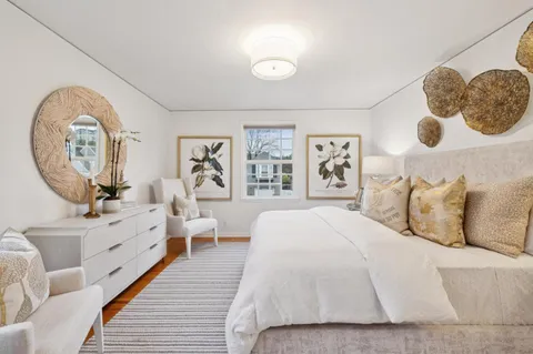 a spacious bedroom with a large bed and a chandelier