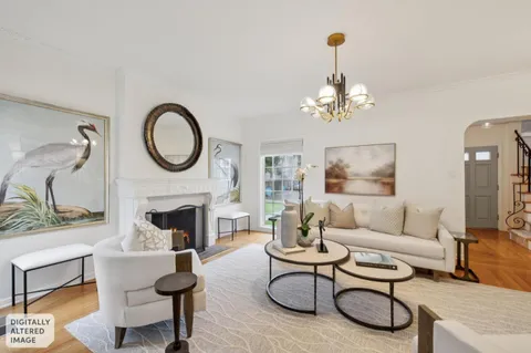 a living room with furniture a fireplace and a chandelier
