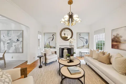 a living room with furniture a chandelier and a fireplace