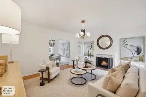 a living room with furniture a fireplace and a chandelier