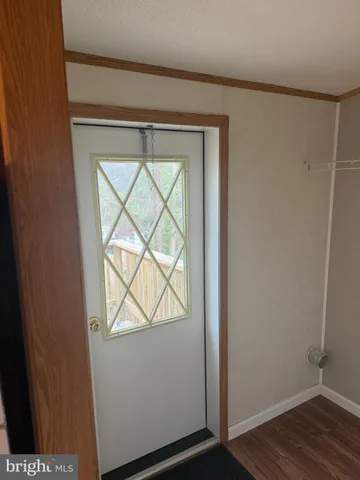 an entryway with wooden floor and cabinet