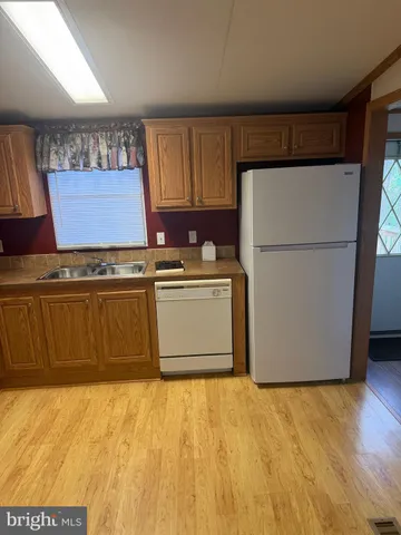 a kitchen with a stove top oven cabinets and a refrigerator