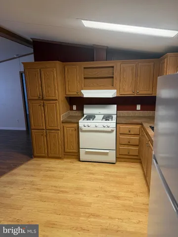 a kitchen with stainless steel appliances granite countertop a refrigerator a stove and a sink