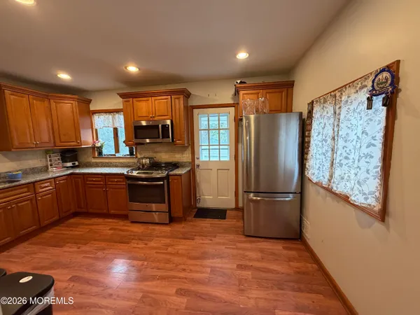a kitchen with granite countertop a refrigerator stove top oven and sink