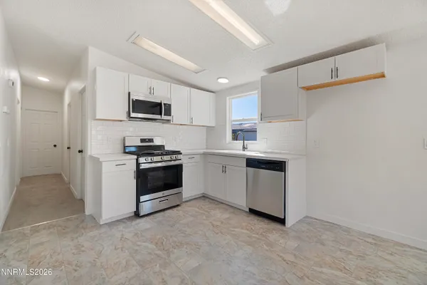 a kitchen with stainless steel appliances a refrigerator stove and microwave