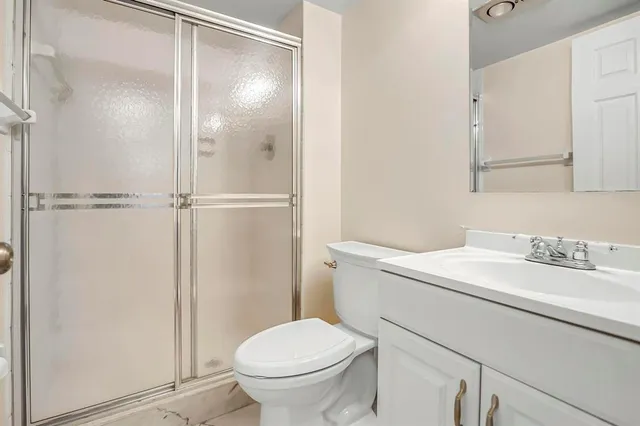 a bathroom with a granite countertop sink toilet and a mirror