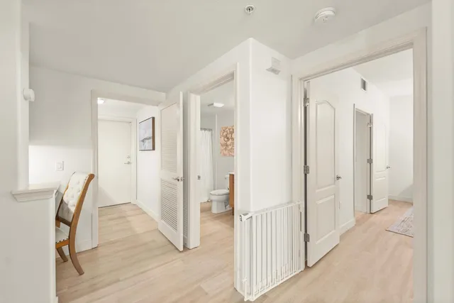 a view of a hallway with wooden floor and staircase