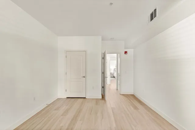 a view of an empty room with closet and a window