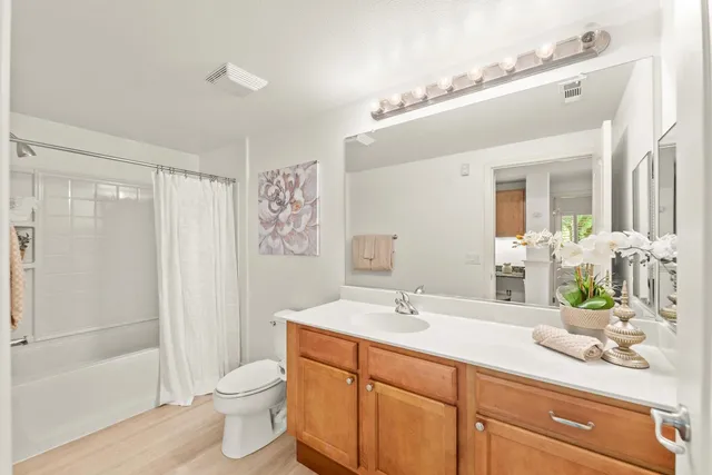 a bathroom with a double vanity sink toilet and shower
