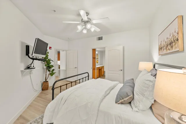 a bedroom with a bed and a flat tv screen on the dresser