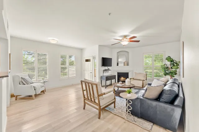 a living room with furniture a fireplace and a large window