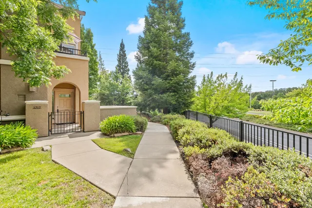 a front view of a house with a yard and potted plants