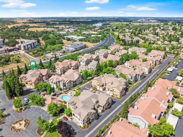 an aerial view of a house with garden space and a car park side of the road