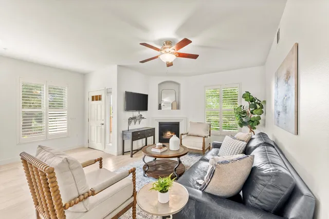 a living room with fireplace furniture and a large window