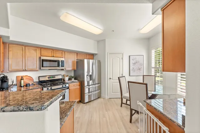 a kitchen with stainless steel appliances granite countertop a refrigerator stove microwave and sink