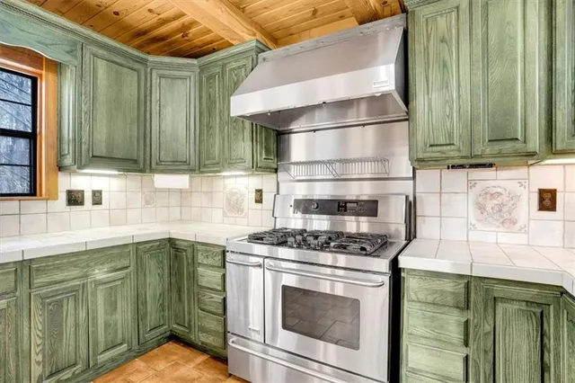 a kitchen with granite countertop a sink a stove and cabinets