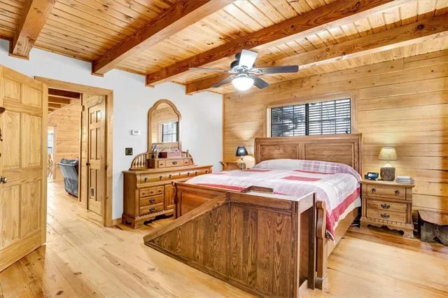 a spacious bedroom with a bed and a dresser next to a window