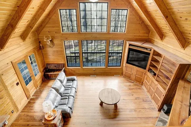 a living room with couches a flat screen tv and kitchen view