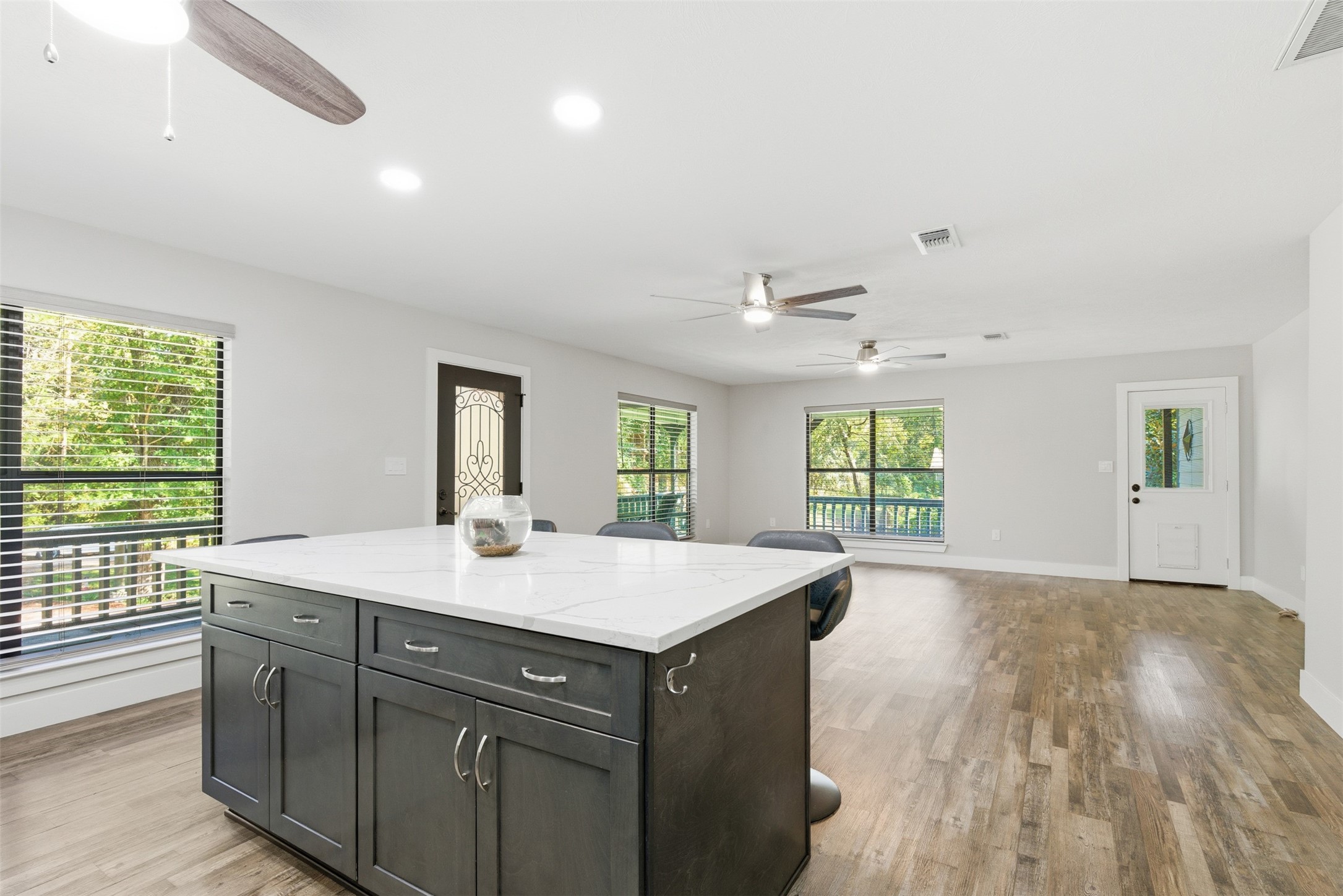 94 Gov Bell Drive Point Blank, TX 77364 - Photo 12 of 49 a hall with kitchen island a stove a wooden floors and a large window