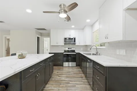 a kitchen with a sink stainless steel appliances and cabinets
