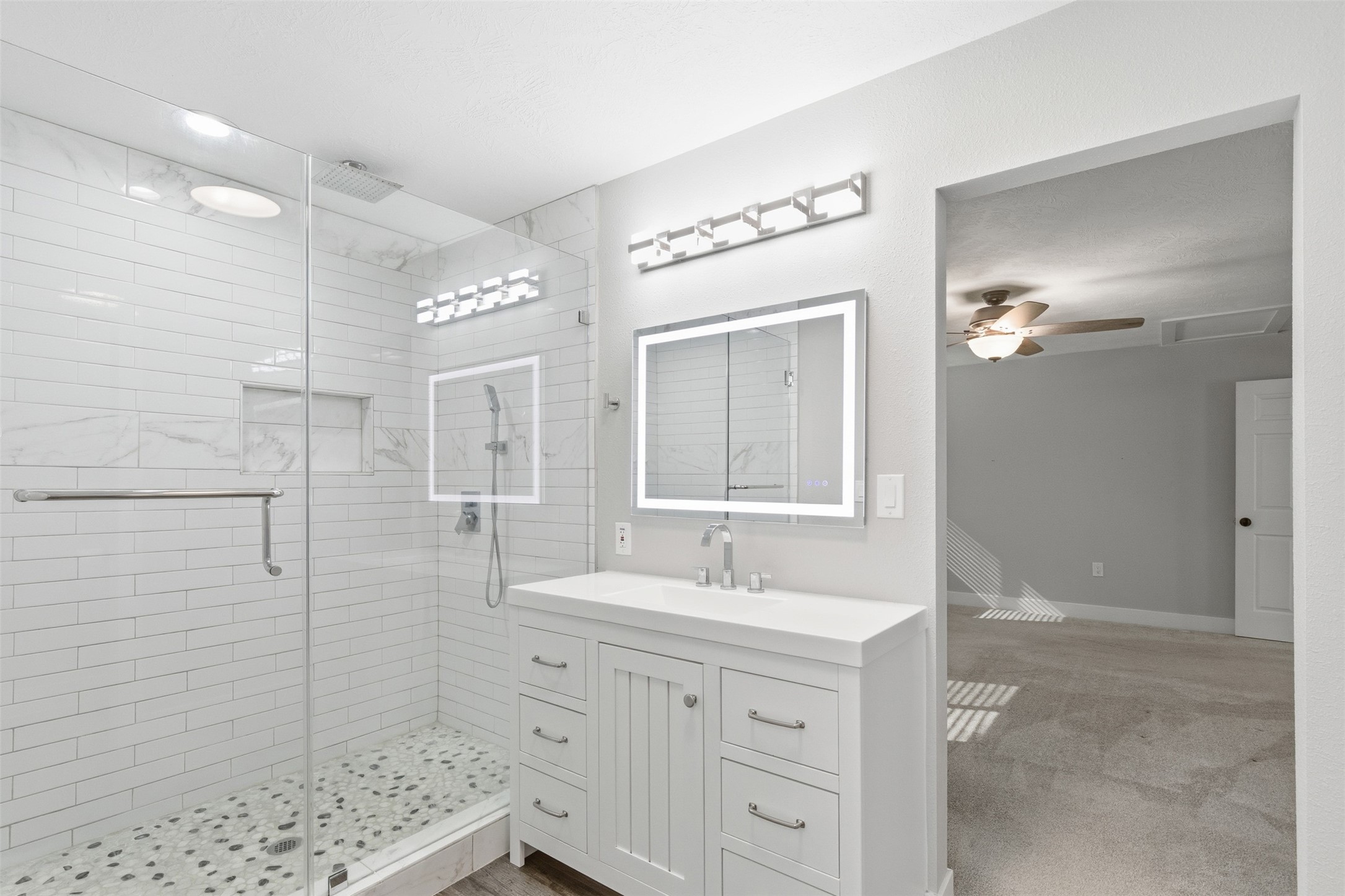 94 Gov Bell Drive Point Blank, TX 77364 - Photo 20 of 49 Completely updated primary bath featuring a sleek design and modern finishes. Enjoy a spa-like standing shower with a rainfall showerhead, a stylish vanity, and a thoughtfully tucked-away toilet for added privacy.