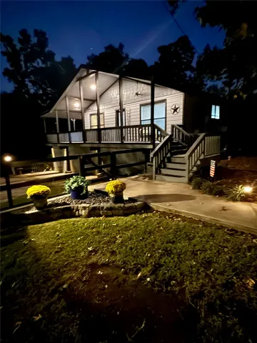 a white house with a big yard and large trees
