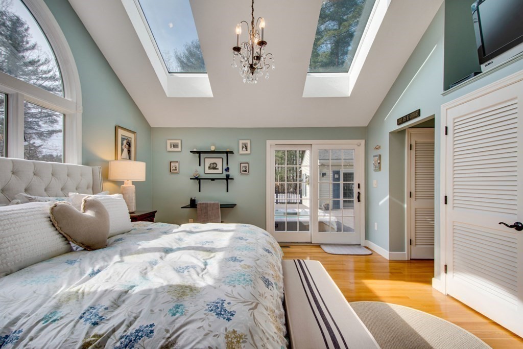 254 Broad Meadow Road Needham, MA 02492 - Photo 11 of 24 a bedroom with a large bed and a chandelier