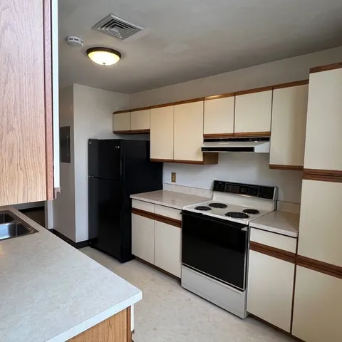 a kitchen with stainless steel appliances granite countertop a refrigerator and a stove top oven