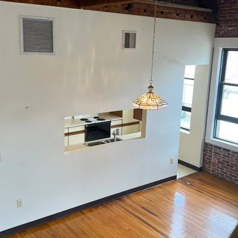 a view of staircase with a large window and wooden floor