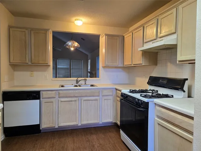 a kitchen with stainless steel appliances granite countertop a sink stove and cabinets