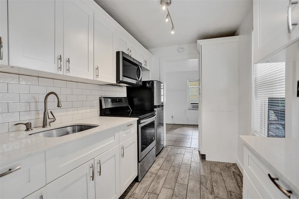 1818 Florida Avenue West Palm Beach, FL 33401 - Photo 31 of 50 a kitchen with stainless steel appliances granite countertop a sink a stove a microwave and cabinets