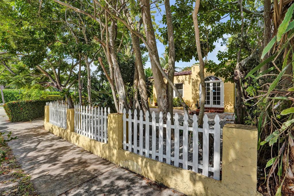 1818 Florida Avenue West Palm Beach, FL 33401 - Photo 10 of 50 a view of a brick house with large trees and wooden fence