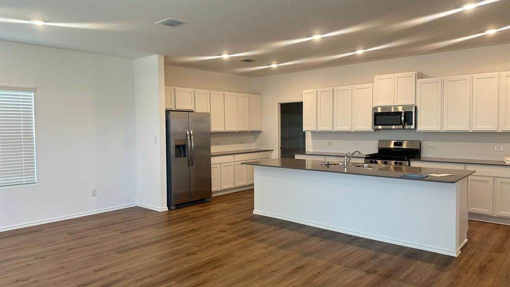 192 Rodney Boat Road Kyle, TX 78640 - Photo 9 of 38 A well-appointed kitchen features stainless steel appliances, ample cabinetry, and an inviting island, perfect for culinary endeavors.