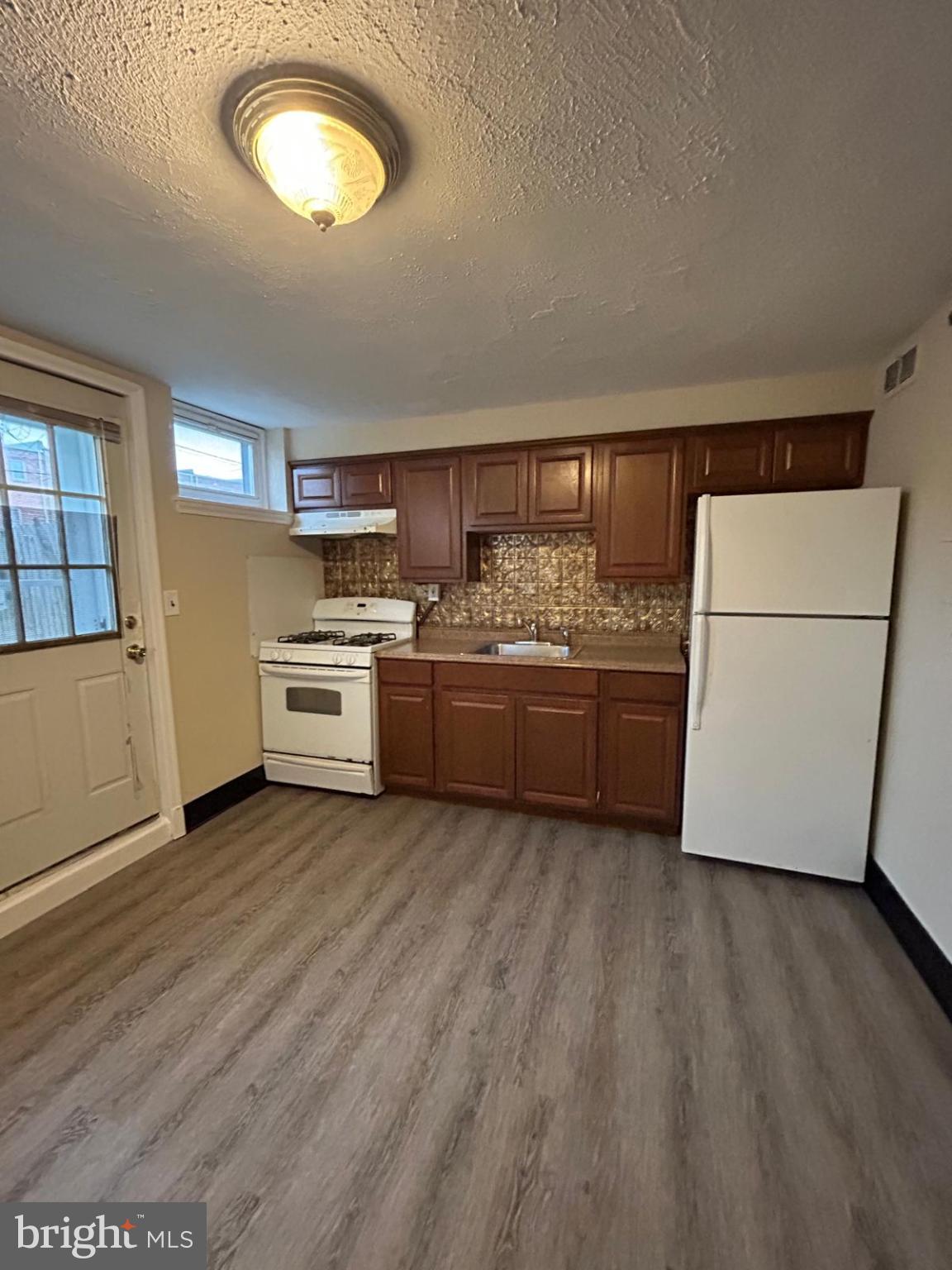 4116 Raymonn Avenue Baltimore, MD 21213 - Photo 3 of 16 a kitchen with a wooden floor and a sink
