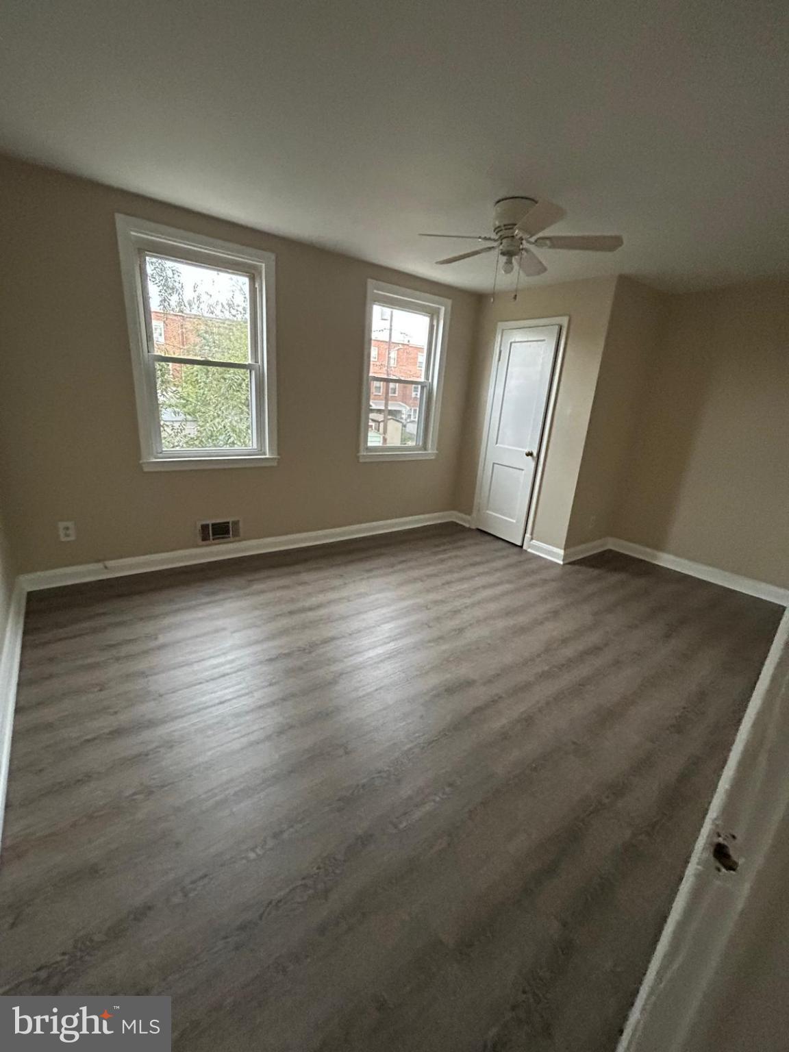 4116 Raymonn Avenue Baltimore, MD 21213 - Photo 6 of 16 an empty room with wooden floor and windows